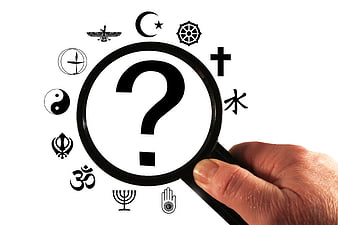 Magnifying glass with question mark over religious symbols