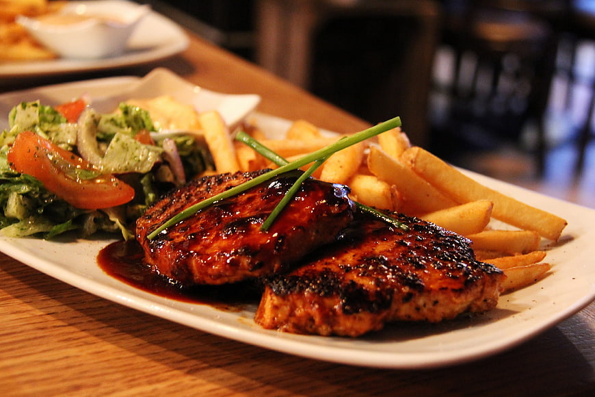 Grilled Pork Chops with Fries and Salad on White Plate