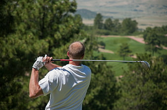 Golfer in White Shirt Swinging Club on Scenic Course