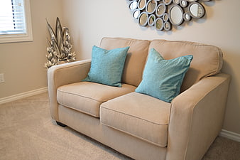Beige Loveseat With Teal Pillows In Modern Living Room
