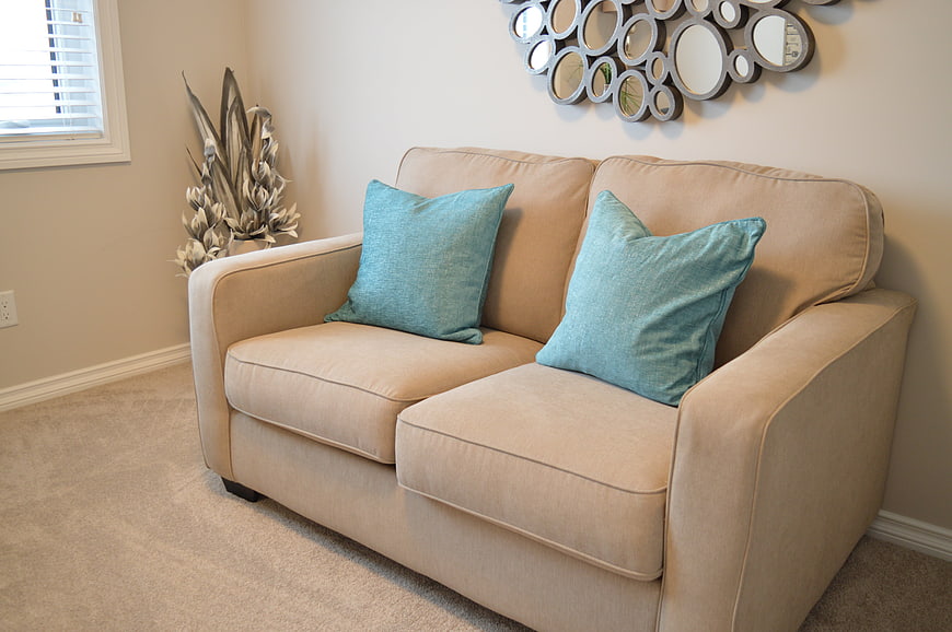 Beige Loveseat With Teal Pillows In Modern Living Room