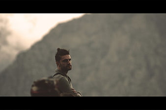 Man with Top Knot Looking at Mountain Landscape