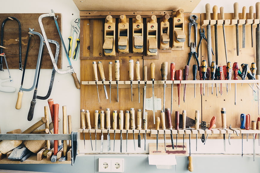Organized woodworking tools on a wall rack