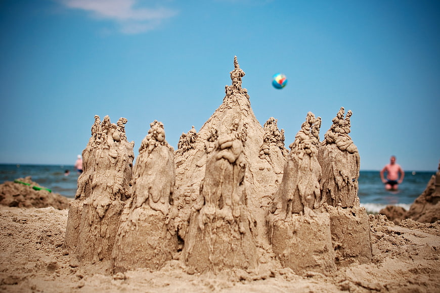 Detailed sand castle on sunny beach with blurred background