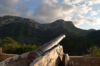 Old Cannon Pointing at Rocky Mountains at Sunset