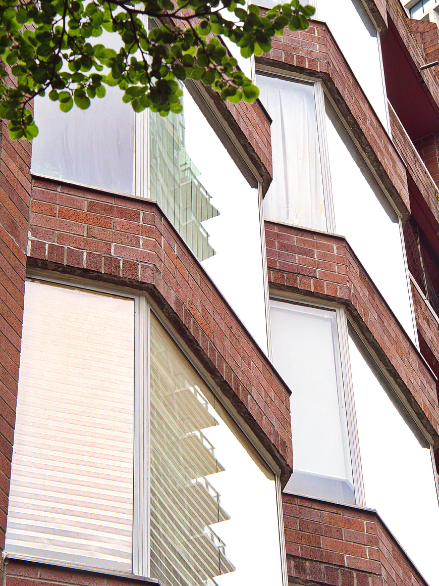 Modern Brick Building Facade with Windows and Tree Branches