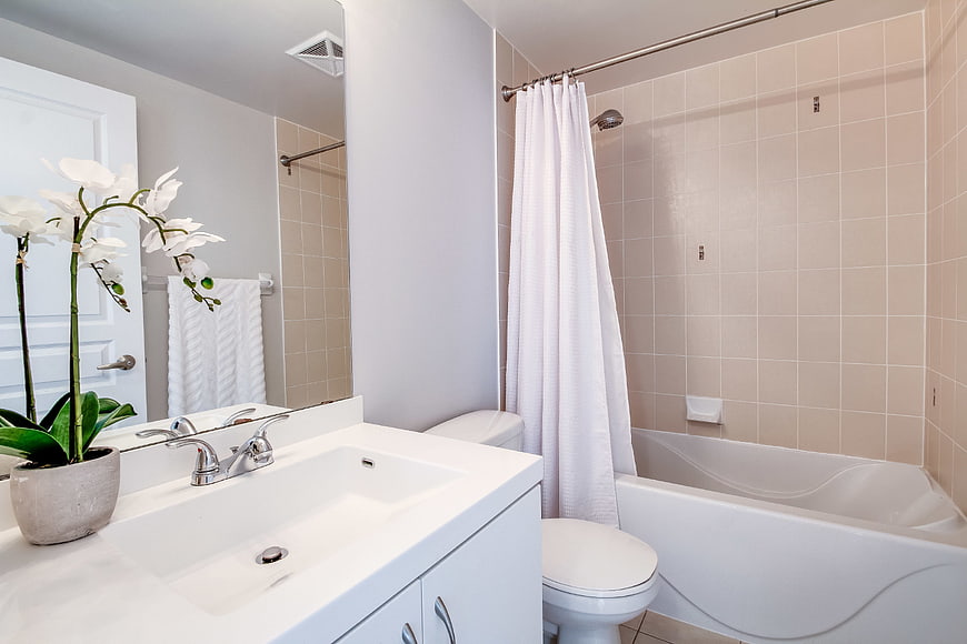 Bright Modern Bathroom Interior With White Vanity And Bathtub