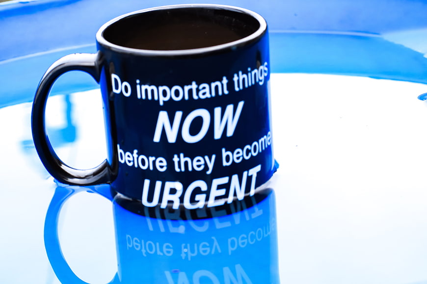 Black Coffee Mug with Motivational Quote on Blue Surface