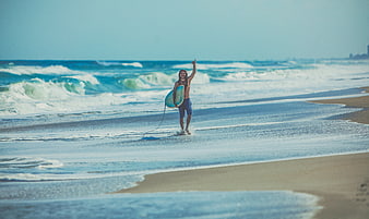 Happy Surfer Walking on Beach with Board