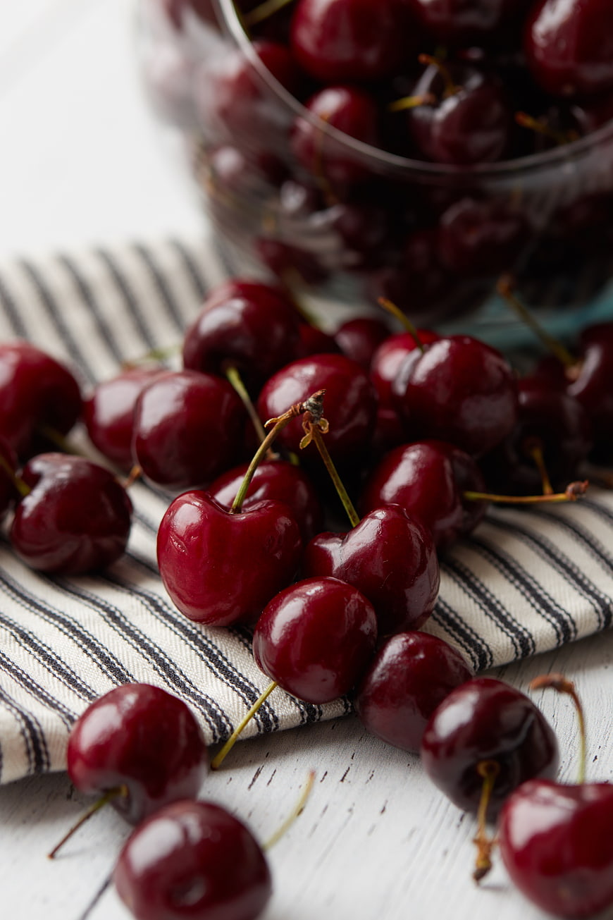Fresh Red Cherries Spilled on Striped Cloth