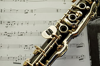 Close-up of a clarinet with silver keys resting on sheet music