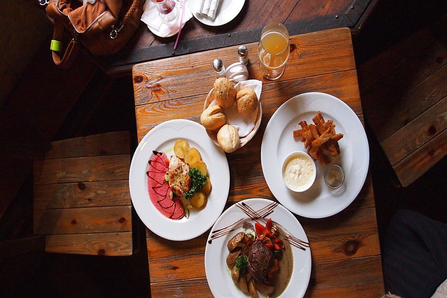 Overhead view of gourmet dinner plates on rustic wooden table