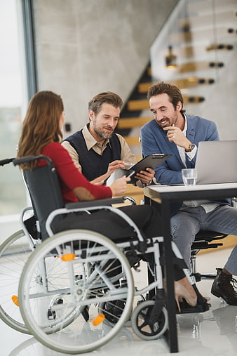 Business meeting with woman in wheelchair discussing strategy