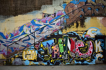 Colorful Graffiti Art on Urban Wall with Metal Staircase