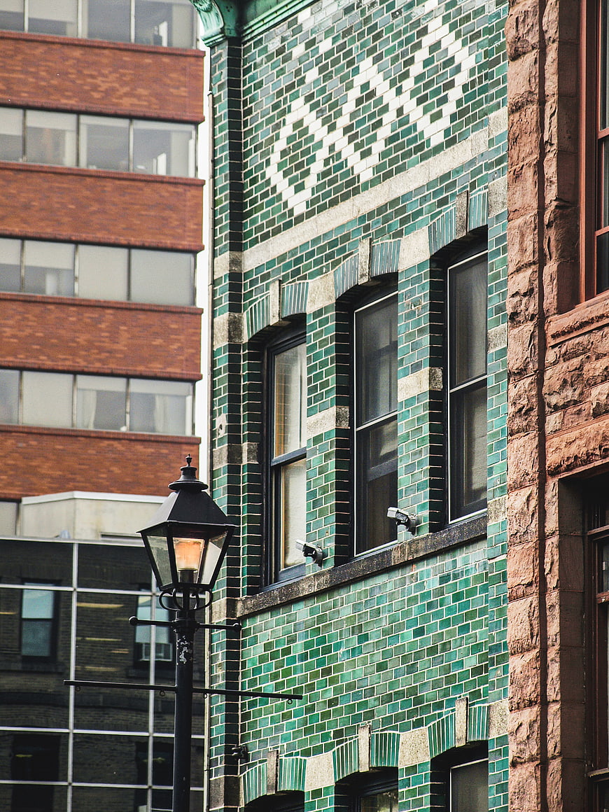 Green tiled building facade with vintage street lamp