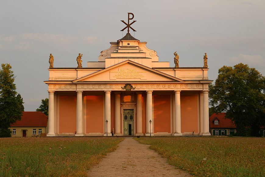 Classical chapel with columns and statues in golden evening light