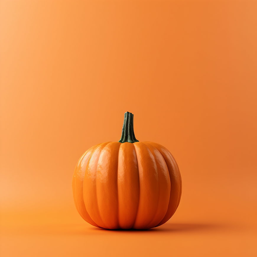 Small orange pumpkin on solid orange background