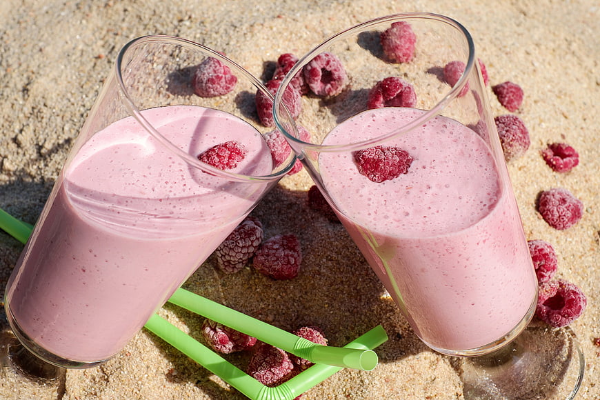 Raspberry Smoothie on Sand with Frozen Berries