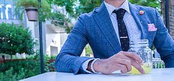 Man in Blue Plaid Suit with Drink at Outdoor Table