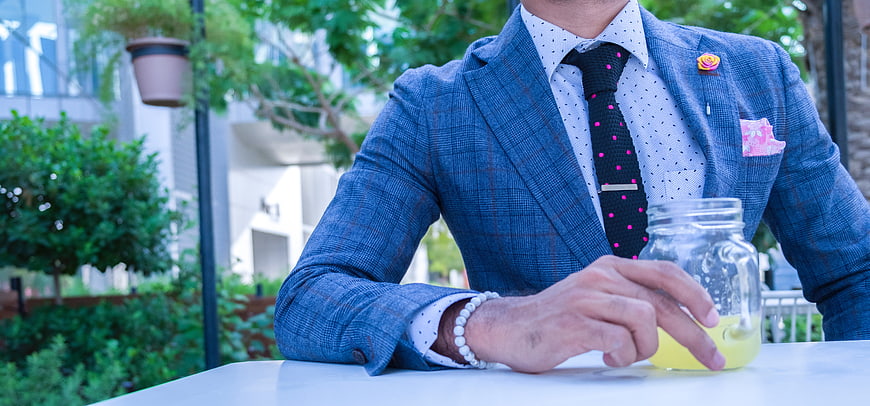 Man in Blue Plaid Suit with Drink at Outdoor Table