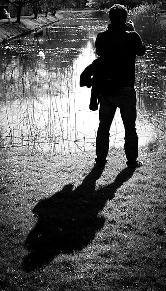 Silhouette of Man Taking Photo by River
