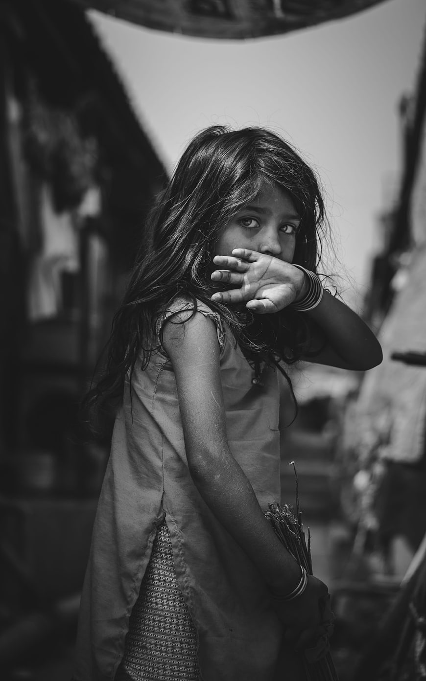 Black and white portrait of young girl covering mouth