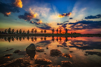Dramatic sunset landscape with vibrant sky reflection in water
