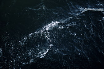 Aerial View of Dark Ocean Waves with White Foam