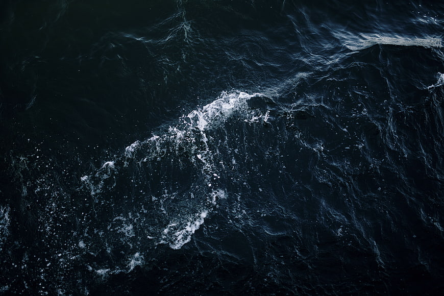 Aerial View of Dark Ocean Waves with White Foam