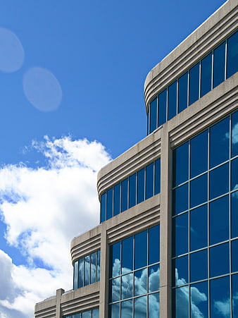 Modern Office Building Facade with Blue Sky and Cloud Reflections