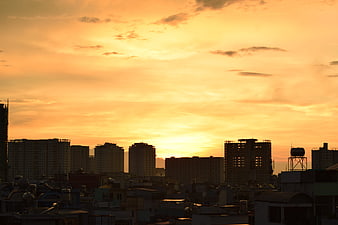 City Skyline Silhouette Against Vibrant Orange Sunset Sky