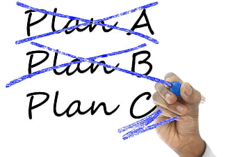 Hand crossing out Plan A and B on whiteboard