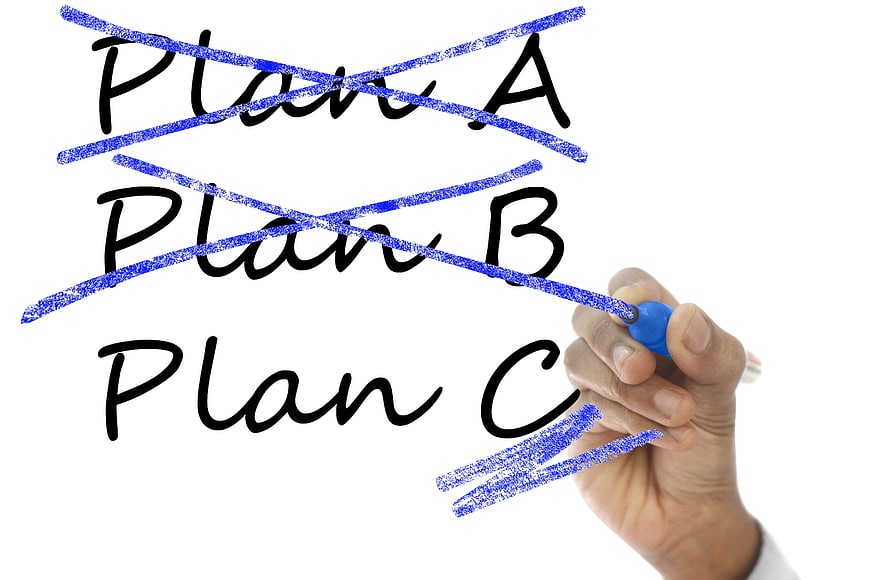 Hand crossing out Plan A and B on whiteboard