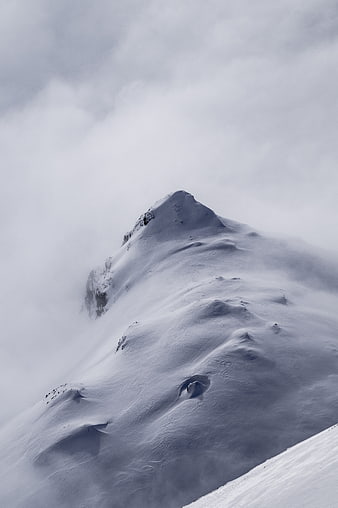 Snowy Alpine Mountain Peak Emerging From Thick Winter Fog