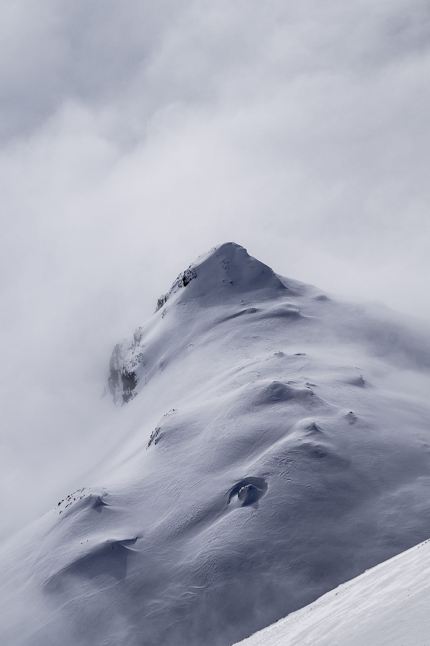 Snowy Alpine Mountain Peak Emerging From Thick Winter Fog