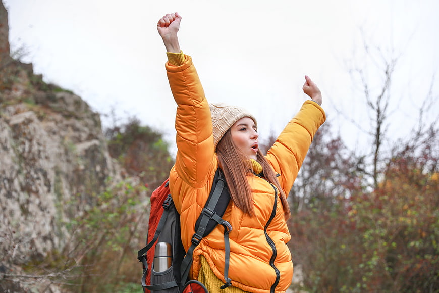 Happy Woman Hiking with Backpack in Nature