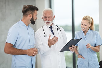 Senior Doctor Discussing Medical Records with Nursing Staff