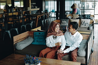 Happy Muslim couple sitting together in a cozy cafe