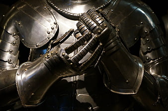 Close-up of medieval knight armor with clasped hands in prayer