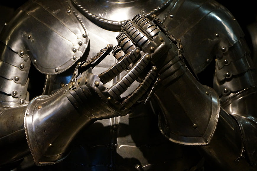 Close-up of medieval knight armor with clasped hands in prayer