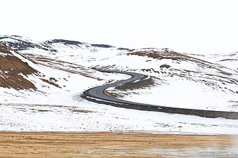 Winding road through snowy mountain landscape in winter