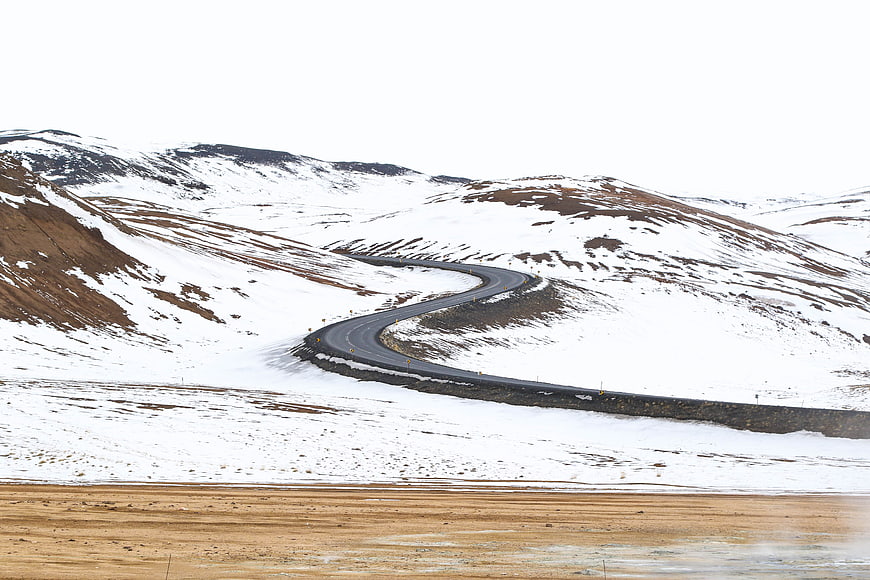 Winding road through snowy mountain landscape in winter