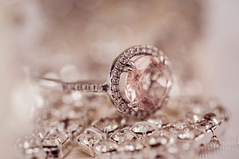 Close-up of elegant pink gemstone ring with diamond halo