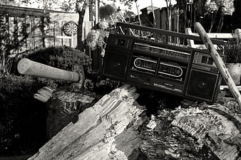 Vintage boombox and axe on chopped wood outdoors