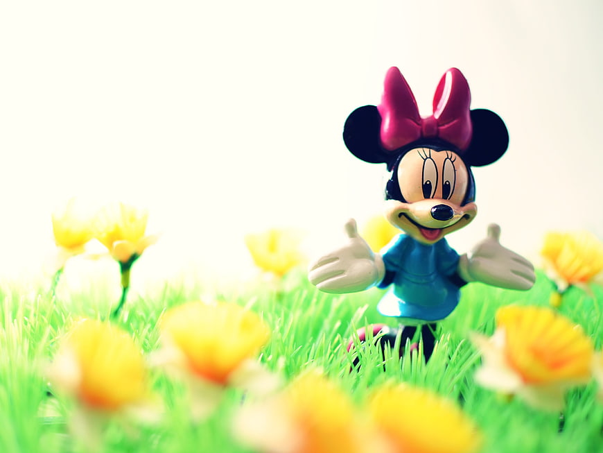 Minnie Mouse Toy Figure In Spring Grass With Yellow Flowers