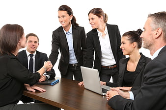 Business team shaking hands around conference table