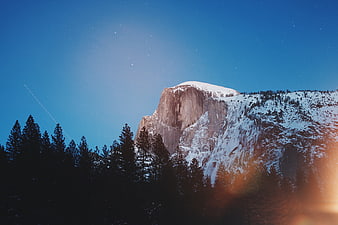 Snow-Capped Granite Mountain Peak at Night with Starry Sky