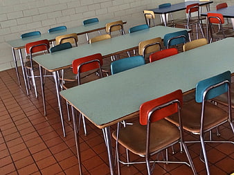 Empty school cafeteria with colorful chairs and tables