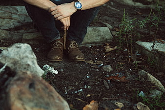 Man Sitting Outdoors with Boots and Watch