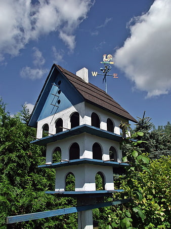 Blue and white multi-level birdhouse with weather vane